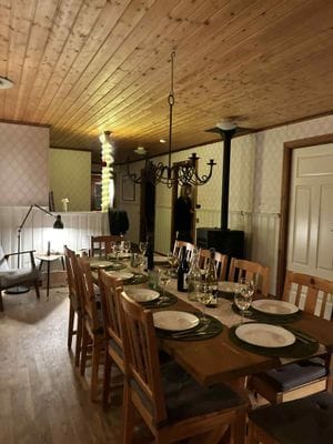 Kök med rymlig matplats, köksö, pelletskamin och två fåtöljer