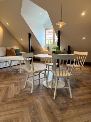 Matplats i anslutning till vardagsrum där det finns en bäddsoffa. Fönstret har mörkläggningsgardiner.