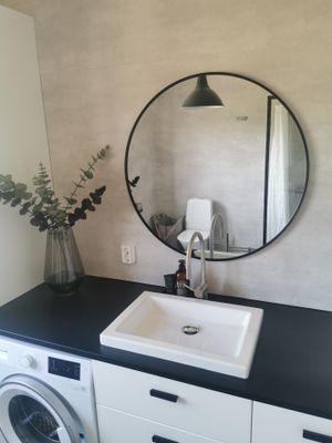 Toalett med dusch och tvättmaskin.