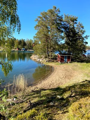 Badstrand och badklippor, litet strandhus med leksaker och solstolar