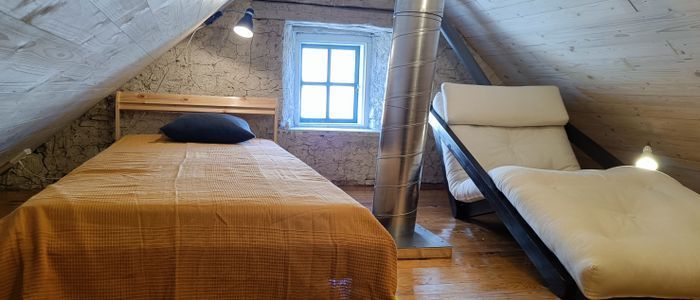 Sovloftet mot söder med en säng och en bäddbar futonfåtölj