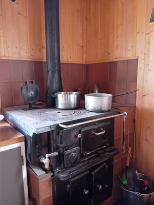 Köksspisen. Tips - ha alltid eld i spisen o två gamla kastruller med vatten igång, så finns alltid varmvatten.