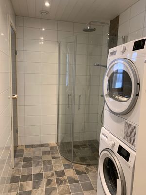 Badrum med WC, takdusch, tvättmaskin och torktumlare på nedre plan.