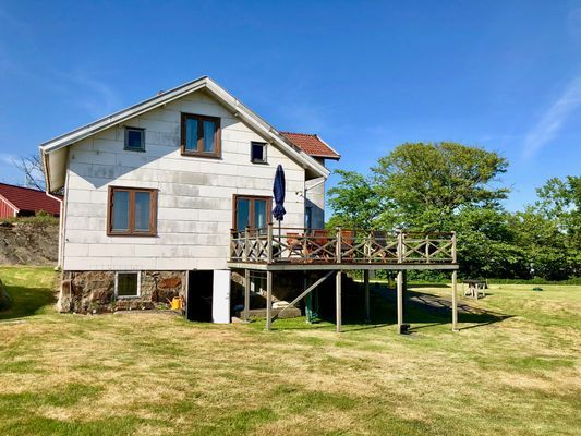 Stor altan med bord, stolar, parasoll och grill