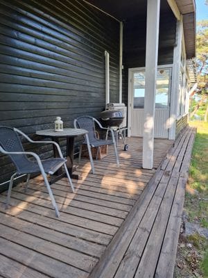 Sittplatser vid långsida av hus mot skogsparti