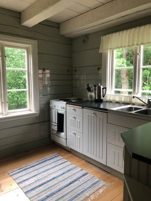 Mysig timmerstuga vid vattenspegel