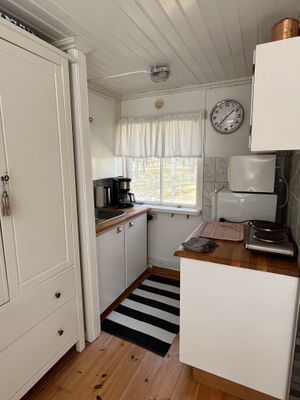 Kokvrå i gäststugan med kokplattor, micro och litet kylskåp med frysfack