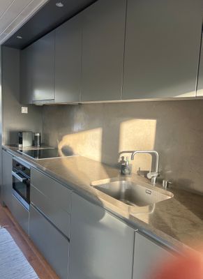 Arkitektritat kök med noggrant utvalda material, integrerad kyl och frys samt vitvaror från Miele.