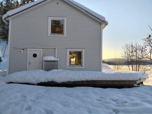 Huset på vintertid med Ångermanälven helt frusen