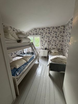 Sovrum med en familjevåningsäng och en separat säng