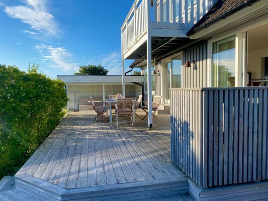 Stor uteplats med matbord och grill
