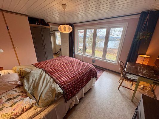 Bild 3 på Stuga med sjöutsikt genom trädtopparna