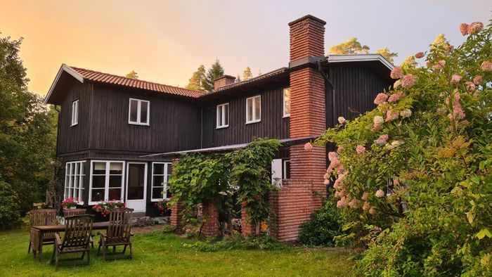 Stort lantligt hus vid skog, sjö och badstrand