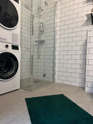 Stort badrum med tvättmaskin och torktumlare