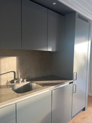 Arkitektritat kök med noggrant utvalda material, integrerad kyl och frys samt vitvaror från Miele.