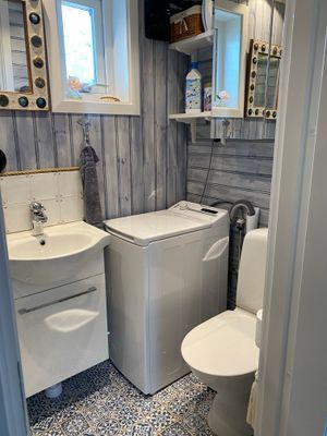 Badrum med tvättmaskin och dusch