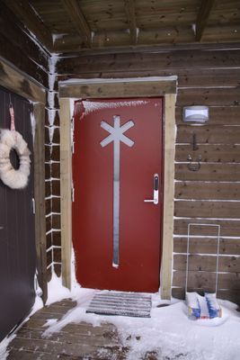 Entrédörr med vackert spårkryss och skidförråd till vänster.
