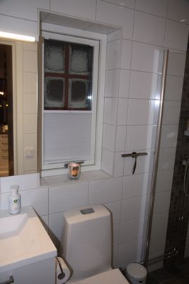 Badrum med WC och takdusch på övre plan.