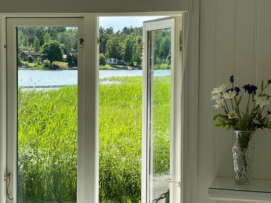 Sjöutsikt från sovrummet (båda fönstren i rummet har rullgardiner )