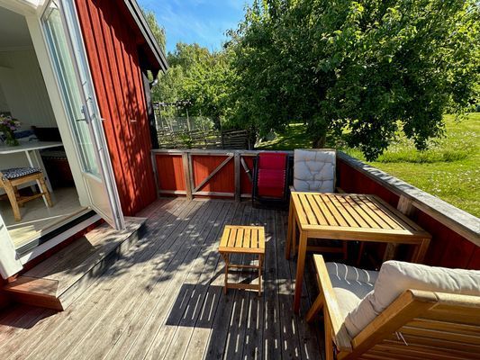 Terrassen har en liten röd dörr som leder till trädgården