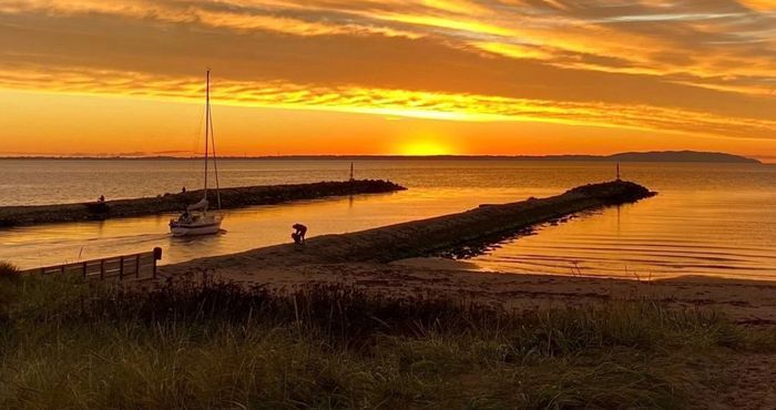 Kvällsbild av pirarna och Hunnabadet.