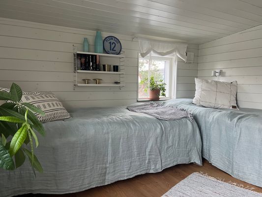 Ljust sovrum på övre våningen med två enkelsängar.