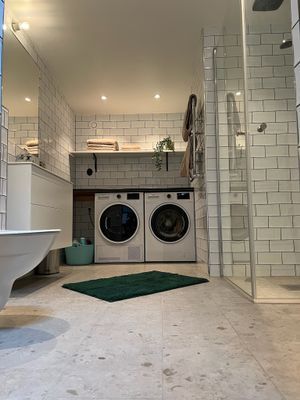 Stort badrum med tvättmaskin och torktumlare