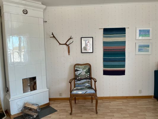 Stort sovrum med kakelugn på bottenplan.