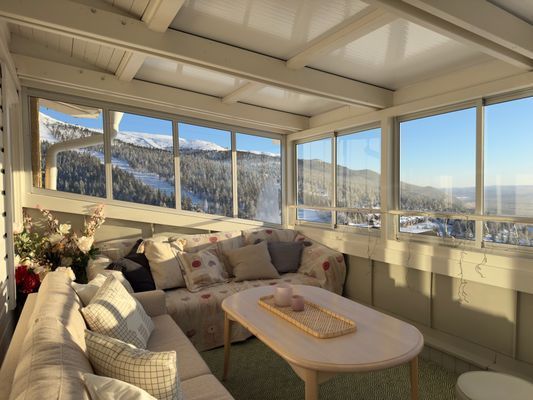 Solig inglasad terass med gott om sittplatser.