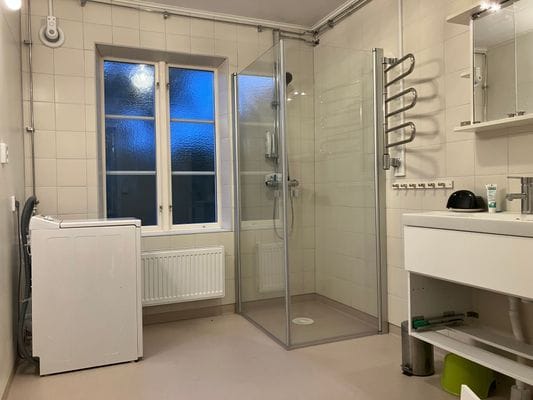 Dusch och tvättmaskin i badrum