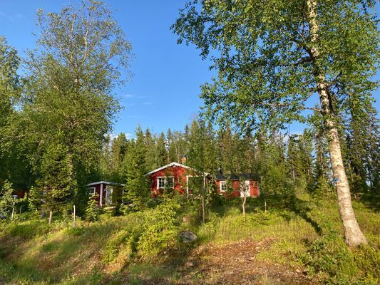 Ombonad stuga vid spår och sjö i Harsa