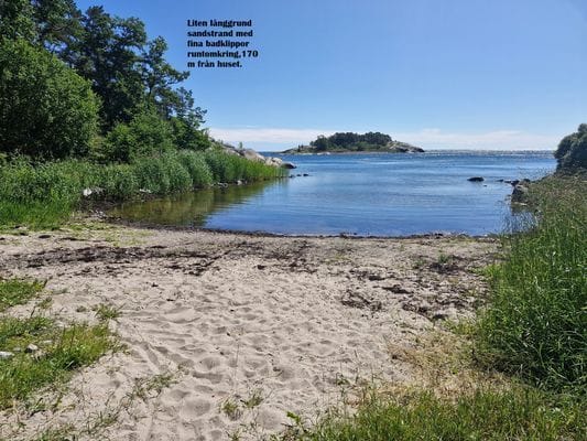 Sandstrand med många badklippor 170 m från huset mot Ålands hav