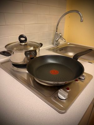 Fullt utrustat kompakt kök med två spisplattor, mikrovågsugn, kyl med frysfack, diskho, köksfläkt och allt du behöver för matlagning.