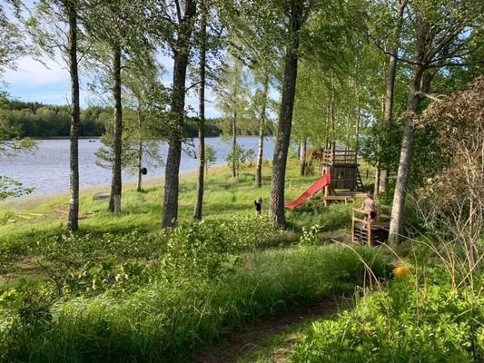Stor trädgård för lek med rutschkana och linbana