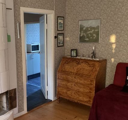 Ingång till vardagsrummet från kök, kakelugn dock ej i bruk.