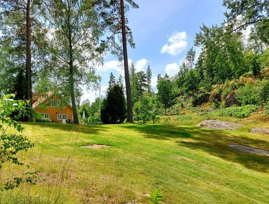 Eget parkområde med två platser att sitta vid, trampolin och eldplats vid sjön.