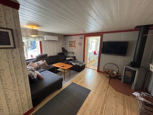 Vardagsrum med stor soffa och kamin