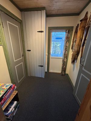 Hall mellan sovrummen. Hylla med spel, böcker och pussel