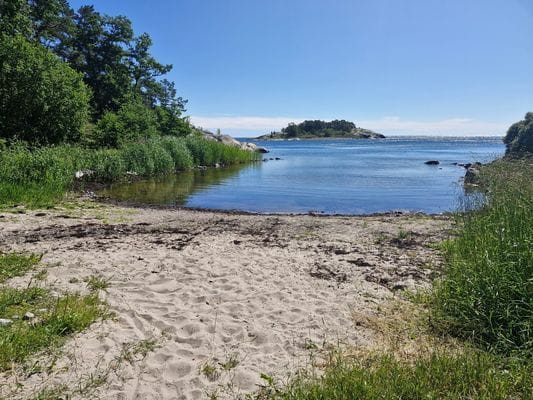 Långgrund sandstrand nära huset. Med gott om fina baklippor runtomkring.