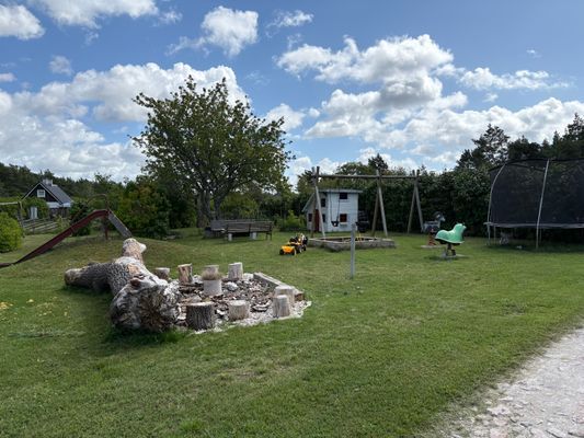 Lekplatsen- rutschkana, studsmatta, gungor, gungdjur, sandlåda och lekstuga