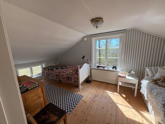 Stort ljust sovrum med en enkelsäng och en bäddsoffa som blir en dubbelsäng, klädförvaring, fin utsikt och mörkläggningsgardiner