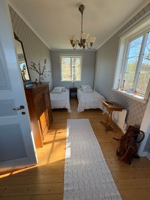 Ljust sovrum med fönster i tre lägen, utsikt över sjön, mörkläggningsgardiner samt skrivbord/arbetsplats