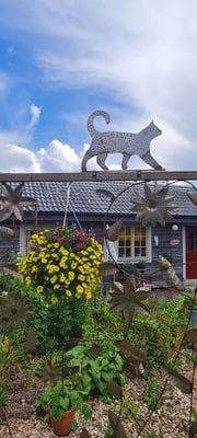 En svetsad spalje, som vi tillverkat, framför timmerstugan Lugnet