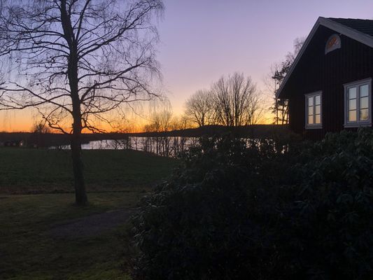 HÖST: SOLNEDGÅNG ÖVER SJÖN, SYDLIGA SIDAN AV STUGAN