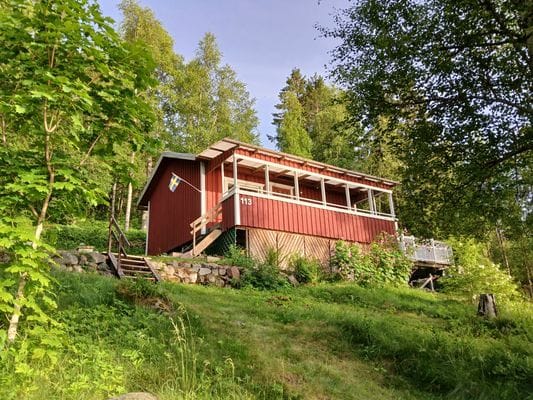 Liten stuga mellan sjö och skog