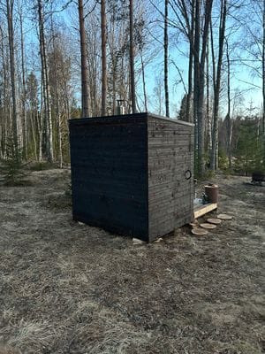 Vedeldad bastu, stort fönster på andra sidan