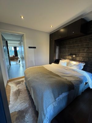 Huvudsovrum med dubbelsäng, platsbyggd förvaring i form av garderob och kroklister, sänglåda under sängen som kan nyttjas av gäster