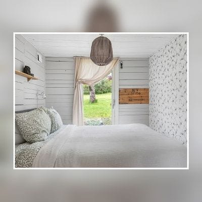 Bekvämt sovrum med dubbelsäng i huvudstugan.