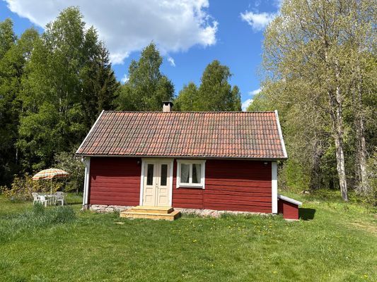 Timrad stuga nära sjö och bad
