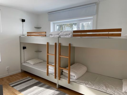 Sovrum 2 med platsbyggda sängar. Varje säng har en egen lampa och hylla